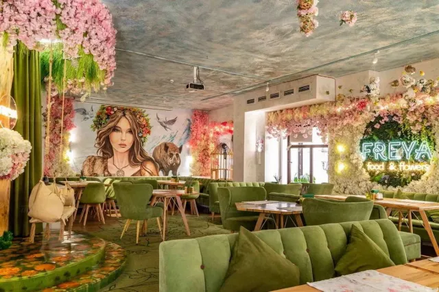 Cafe interior with green sofas and FREYA sign on the wall